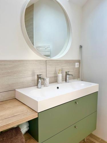 a bathroom with a sink and a mirror at Cadre d'exception et nature - 2 Maisons - 15 pers max in Aigné