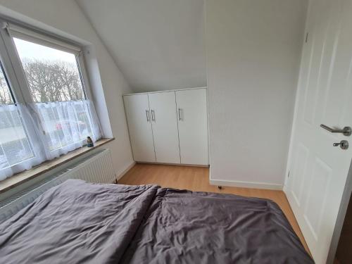 a bedroom with a bed and a window at Ferienwohnung Küstennest Vitzdorf in Fehmarn