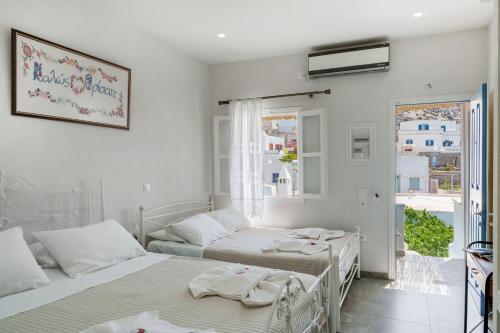 two beds in a room with a window at Politimis Studio N3 in Amorgos