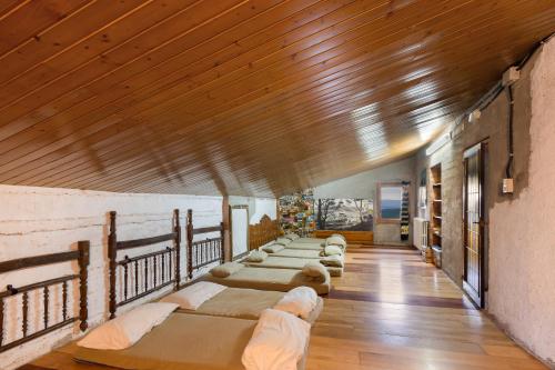 a row of beds in a room with wooden ceilings at Casa refugi les Orenetes in Rocafort