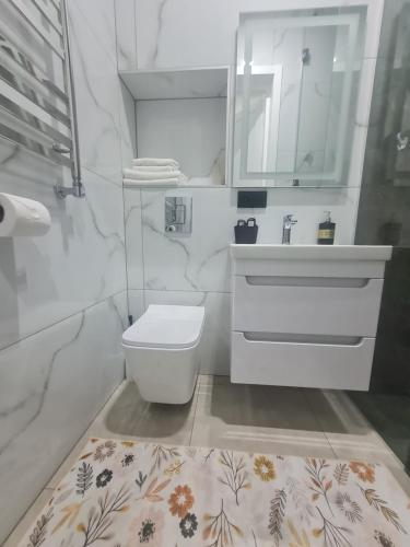 a white bathroom with a sink and a toilet at Апартаменти Центр in Lutsk