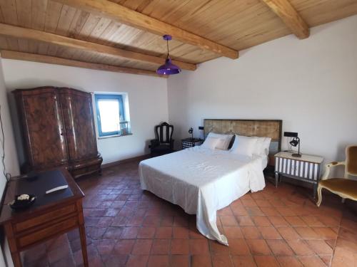 a bedroom with a white bed and a wooden ceiling at Domus Nirale in Bagnoregio