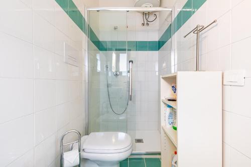 a white bathroom with a shower and a toilet at Trilocale a 200 mt dal centro in San Teodoro
