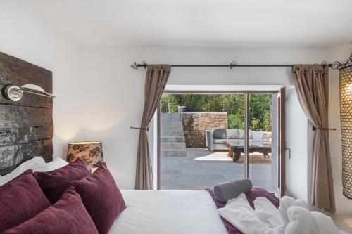 a bedroom with a bed and a sliding glass door at Can Ribes Ibiza in Illes Balears