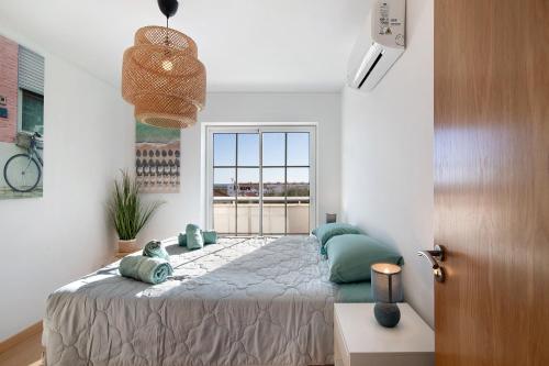 a bedroom with a bed and a large window at Tavira Mar in Cabanas de Tavira