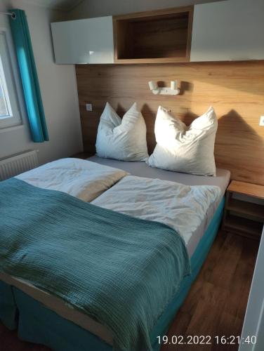 a bedroom with a bed with white sheets and pillows at Ferienhaus Concordia in Friedrichsaue