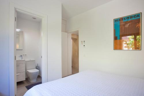 a white bedroom with a bed and a toilet at Villa Mar y Muntana in Banyalbufar