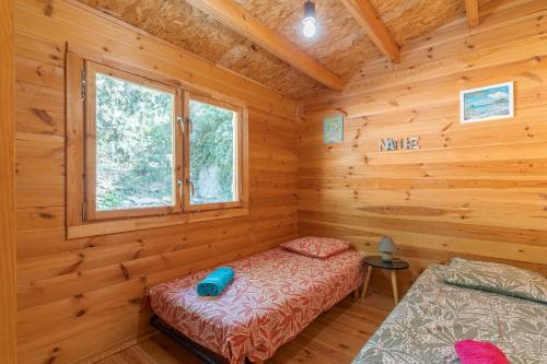 a log cabin bedroom with a bed and a window at Le Colibri in La Ciotat