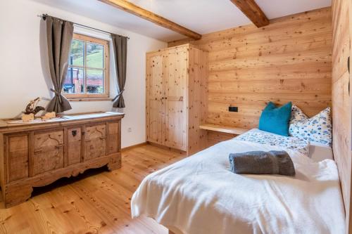 a bedroom with a bed and a wooden wall at Innerforchhof Schnals in Madonna
