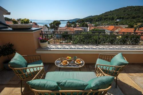 a balcony with chairs and a table with food on it at Heritage Holiday Home Rafica 365 Wellness Retreat in Božava
