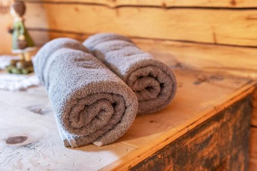 a group of rolled towels sitting on a wooden table at Innerforchhof Schnals in Madonna