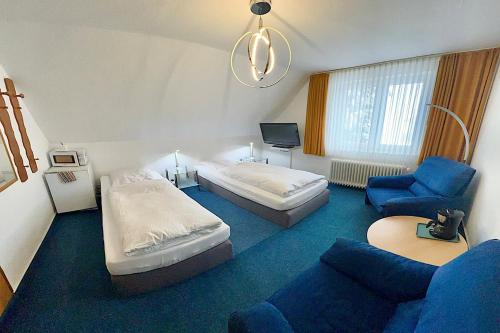 a hotel room with a bed and a couch and a chair at BLACKCOMs Erika in Goslar