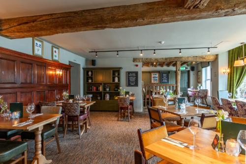 a restaurant with wooden tables and chairs at Balloch House by Innkeeper's Collection in Balloch