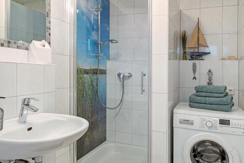 a bathroom with a sink and a washing machine at Ferienwohnung Bruttel in Gaienhofen