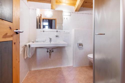 a white bathroom with a sink and a toilet at Mansardenwohnung Egart in Resia