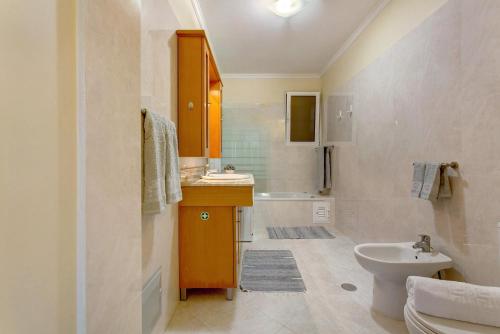 a bathroom with a sink and a toilet and a tub at Refugio Dourado in Água de Pena
