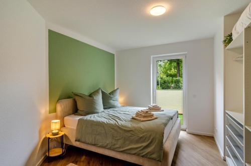 a bedroom with a bed with a green accent wall at Fewo Luisa in Bad Zwischenahn