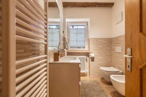 a bathroom with a toilet and a sink and a tub at Casa Lorenz 1 in Canazei