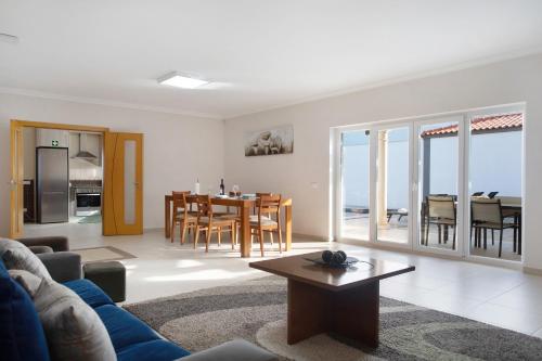 a living room with a blue couch and a table at Villa Rosa com Piscina e Jacuzzi in Salir de Matos
