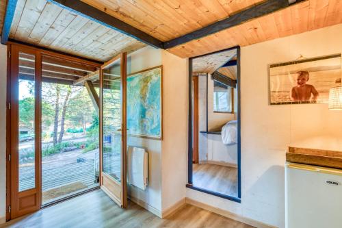 a room with sliding glass doors and a bedroom at Le Sabel - Cabanon in Mourèze