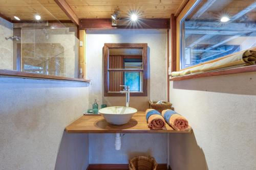 a bathroom with a counter with a sink and a mirror at Le Sabel - Cabanon in Mourèze