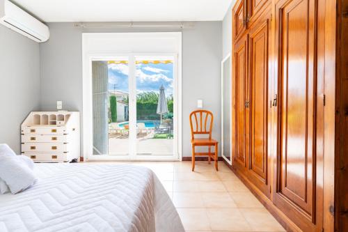a bedroom with a bed and a chair and a window at Mario in Vinarós