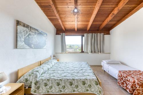 a bedroom with two beds and a wooden ceiling at Villa Liscedde Leuca in Castrignano del Capo