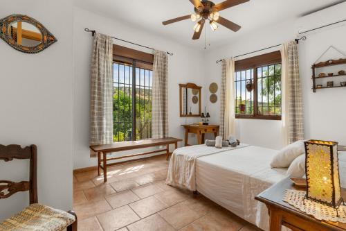 a bedroom with a bed and two windows at Casa Villa Pinale Álora in Alora