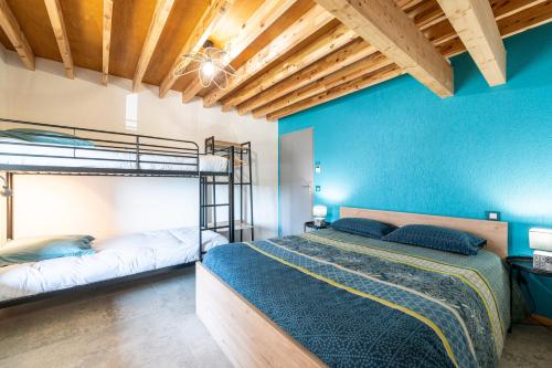 a bedroom with two bunk beds and blue walls at Les Bellevues in Moye