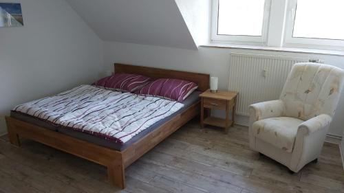 a bedroom with a bed and a chair at Das Landhaus Wohnung 1 in Kirch Mulsow