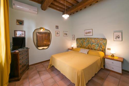 a bedroom with a yellow bed and a mirror at Casa Pel di Lupo in Rosignano Marittimo