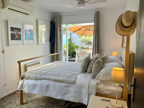 a bedroom with a bed and a patio with an umbrella at El Escondrijo Ibiza in San Antonio