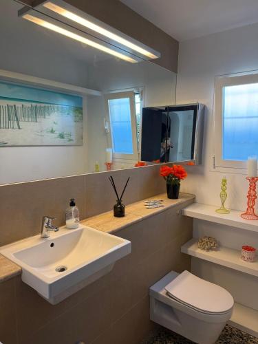 a bathroom with a sink and a toilet and a tv at El Escondrijo Ibiza in San Antonio
