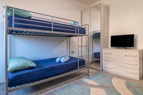 a bedroom with two bunk beds and a television at Thomas' House in Alghero