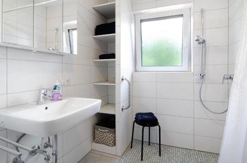 a white bathroom with a sink and a shower at Fewo Fuchs in Salem