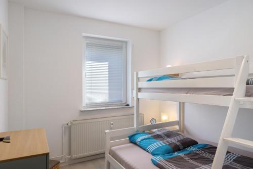 a bedroom with two bunk beds and a desk at Ferienwohnung Kleinbreitenbach in Plaue