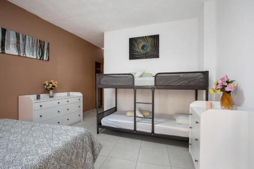 a bedroom with two bunk beds and a dresser at Chez Martine Tenerife in Granadilla de Abona