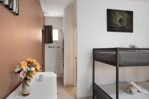 a bedroom with a bunk bed and a vase of flowers at Chez Martine Tenerife in Granadilla de Abona