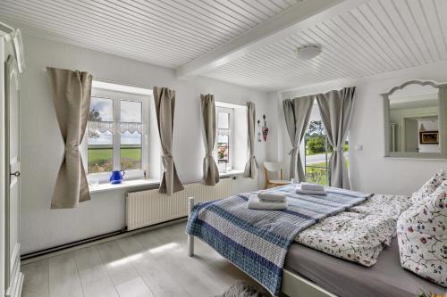 a bedroom with a bed and two windows at Mein Haus in Pellworm