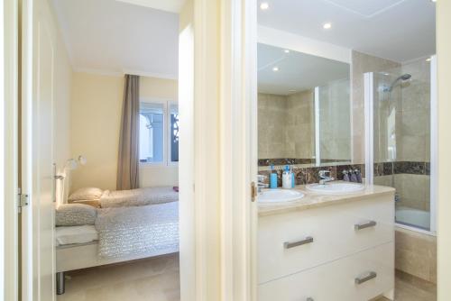 a bathroom with two sinks and a shower at Astonishing view modern apartment in Sitio de Calahonda
