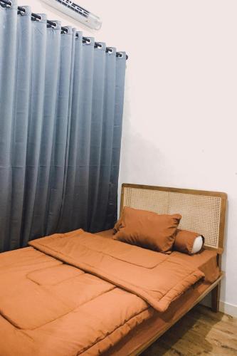 a bed with blue curtains in a bedroom at SS house in Tabanan
