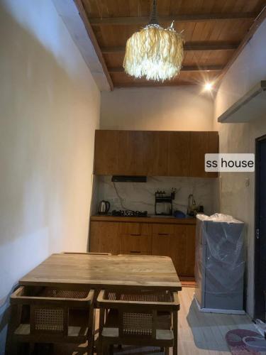 a kitchen with a wooden table in a room at SS house in Tabanan