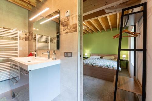 a bathroom with a sink and a bed in a room at Les Bellevues in Moye