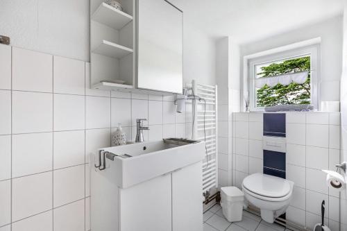 a white bathroom with a sink and a toilet at Mein Haus in Pellworm