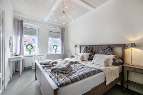 a white bedroom with a large bed and windows at Ferienwohnung Doris in Viöl