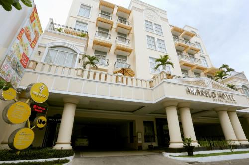 a large white building with a balcony on it at Amarelo Hotel Solo in Solo