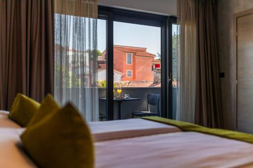 a hotel room with a bed and a large window at Pula City Center Accommodation - Breakfast included in Pula