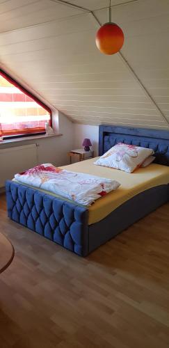 a bedroom with a blue bed in a room with a window at Ferienwohnung Karin in Eltmann