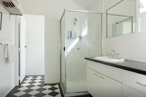 a white bathroom with a shower and a sink at Green Gables in Brisbane