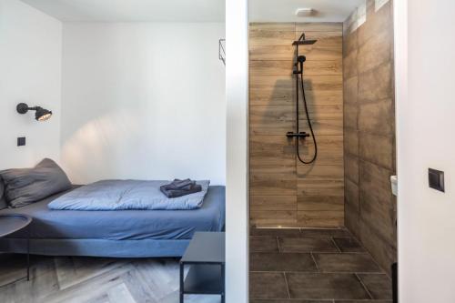 a bathroom with a shower and a bed in a room at Haus Waldberg in Unterschönau